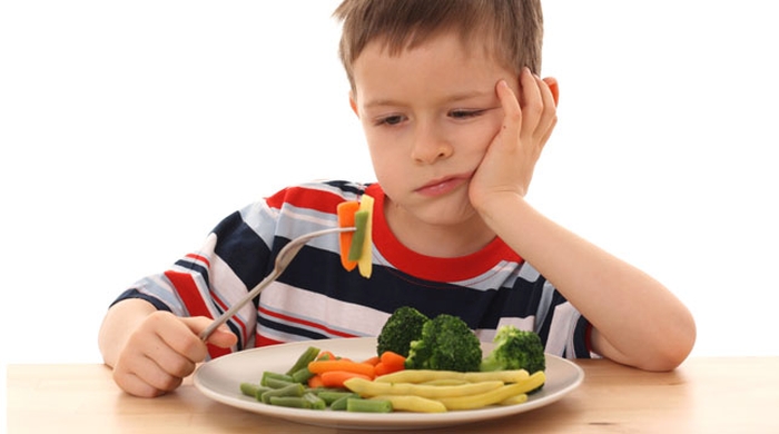 5-6 years old boy and plate of cooked vegetables isolated on white