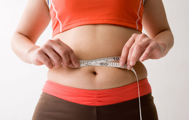 Mid adult woman measuring her waist