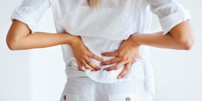 Portrait of young woman suffering from severe back pain