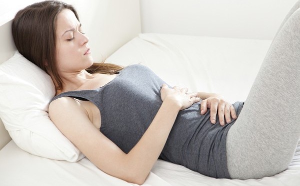 Girl holding her stomach from constipation pain