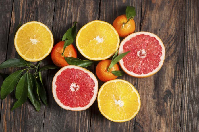 Citrus fruits. Over wooden table background