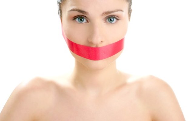 Beautiful woman with red tape on mouth portrait isolated on white