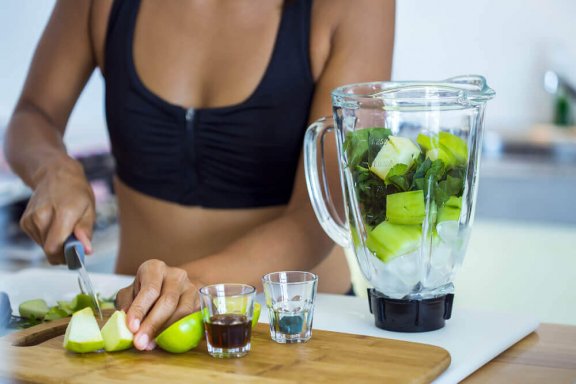 Woman-chopping-fruit-for-a-smoothie-576x384
