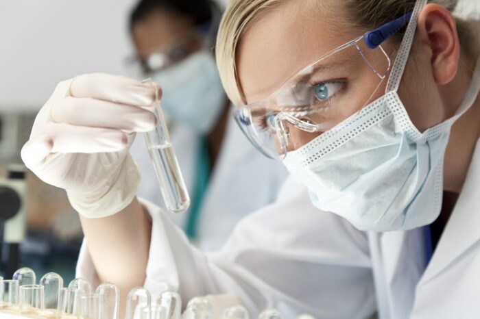 Female Scientific Research Team With Clear Solution In Laboratory